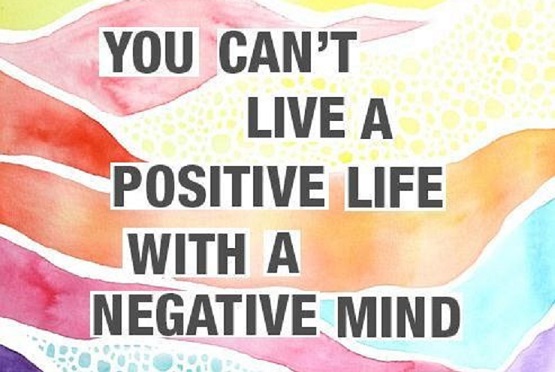 The words "you can't live a positive life with a negative mid" with a rainbow colored background