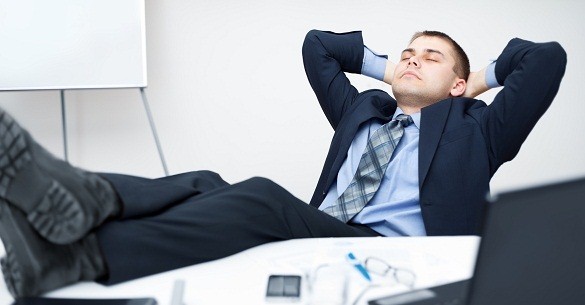 Tired businessman sleeping on chair in office with his legs on t