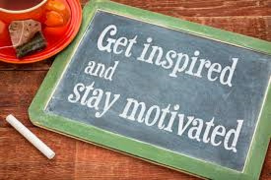 A dry erase board with a green border that says "get inspired and stay motivated" in white chalk