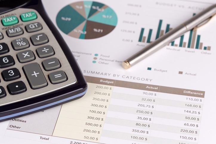 Photo of a calculator and pages of various financial data