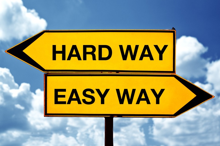 Two signs pointing in opposite directions. One says "hard way", the other says "easy way"