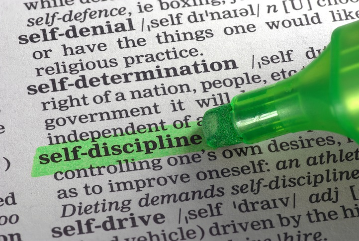 The definition of self-discipline in the dictionary with a highlighter highlighting the word "self-discipline"