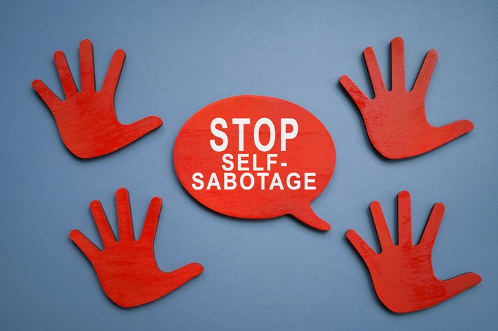 Picture of red hands with speach bubble saying "stop self-sabotage"