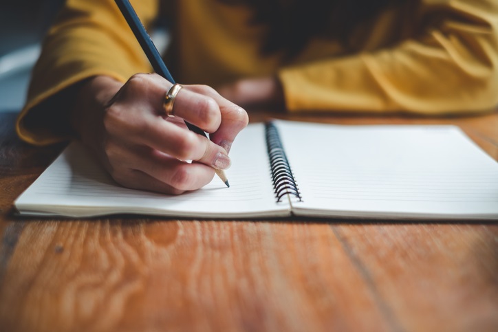 Picture of a person writing in a journal