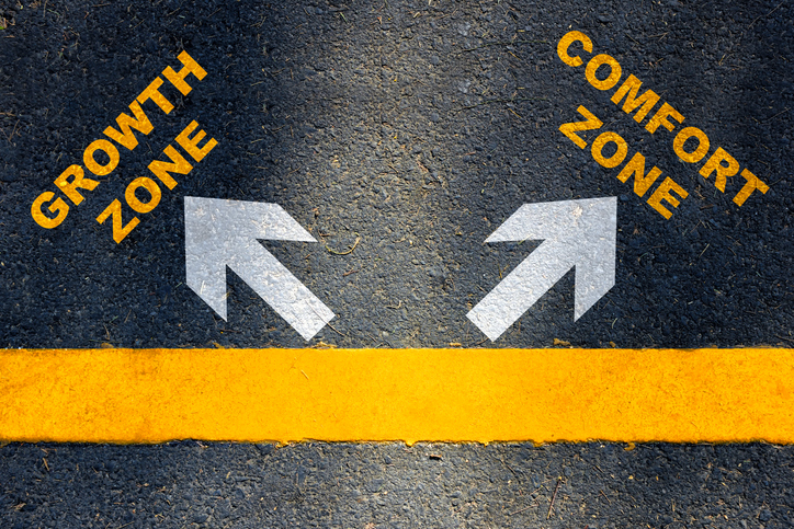 Photo of asphalt ground with a horizontal yellow line painted. Above the line are 2 white arrows pointing in opposite directions, one labeled "growth zone" and one labeled "comfort zone"