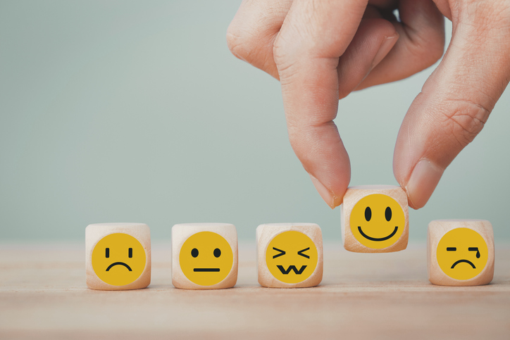 Photo of five small blocks, each with a different face emoji to show different emotions