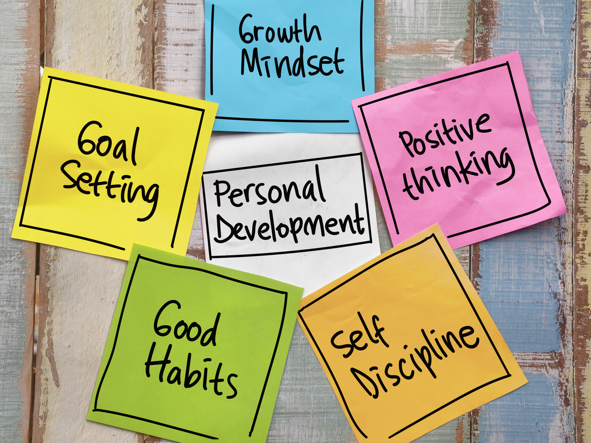 6 post-it notes arranged in a star shape. A blue one says "growth mindset", a yellow one says "goal setting", a white one says "personal development", a pink one says "positive thinking", a green one says "good habits", and an orange one says "self discipline"