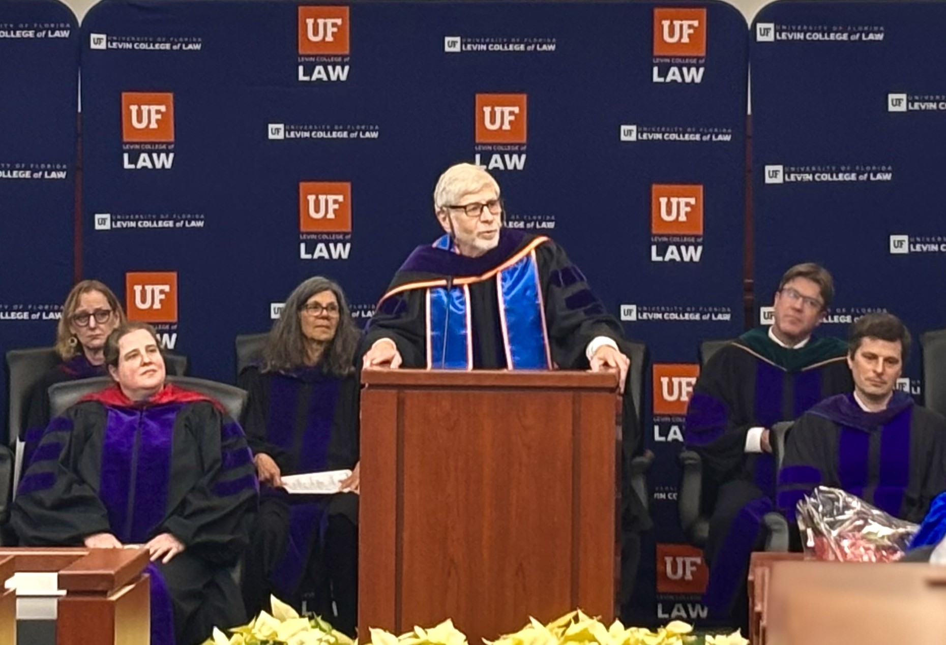 Nathan S Collier standing at a podium delivering commencement speech