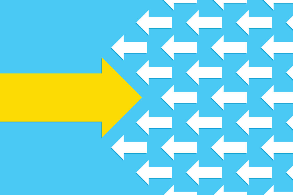 A light blue background with a large yellow arrow pointing to the right, going against several small white arrows pointing to the left