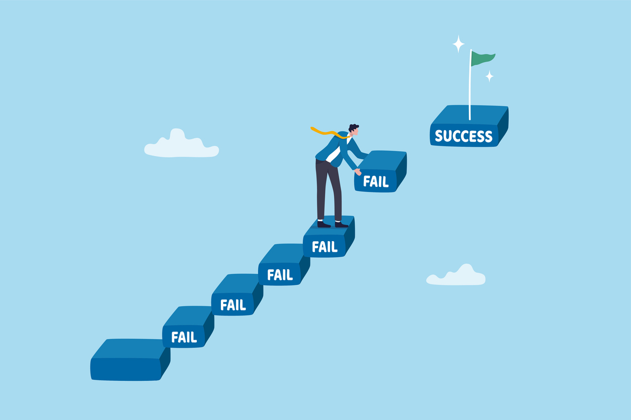 An illustration of a person climbing a staircase made of blocks labeled “FAIL,” using them as steps to reach a higher platform labeled “SUCCESS” with a flag on top—symbolizing learning from failure to achieve success.
