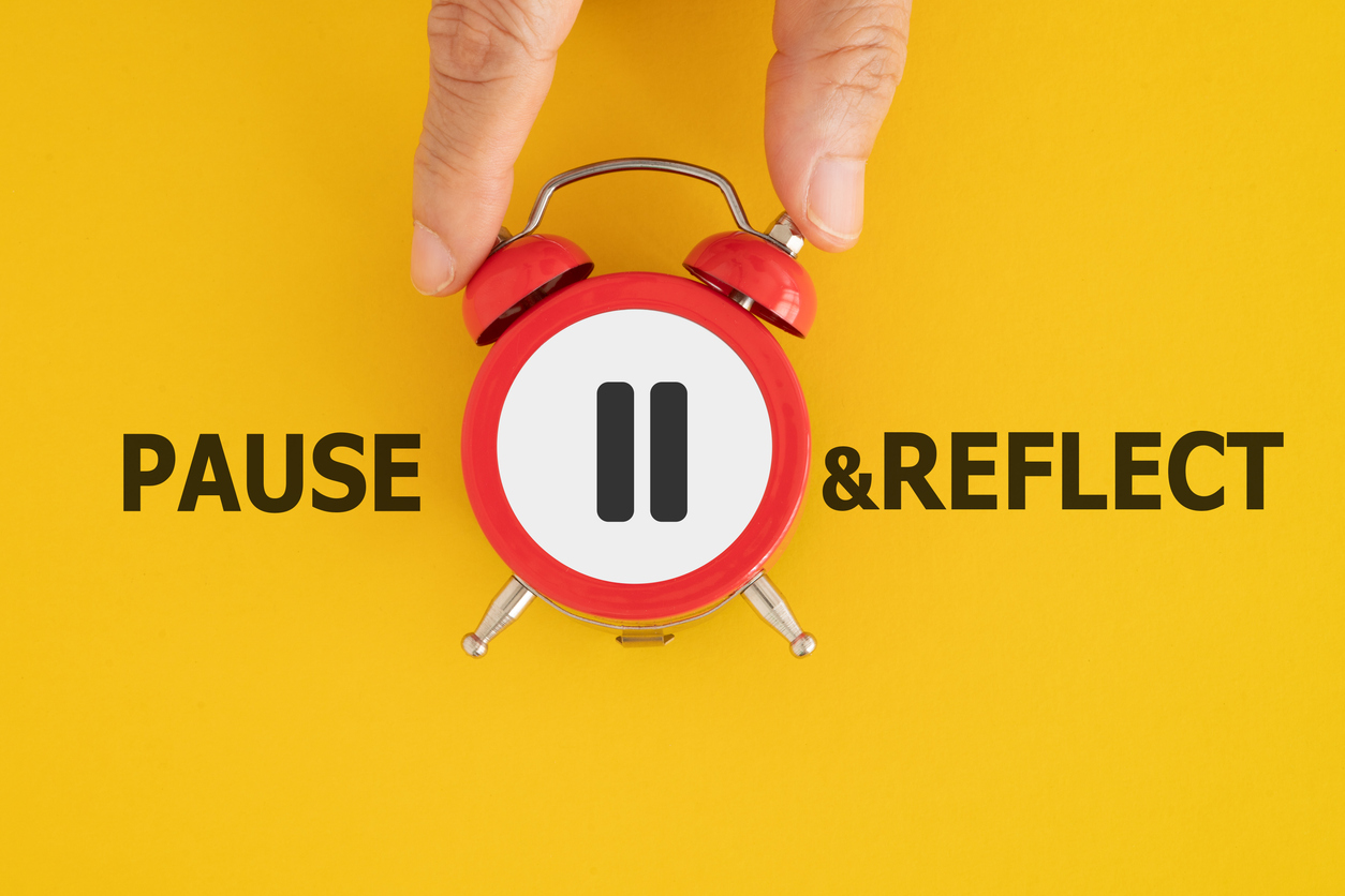 hand holding red clock with stop sign and pause reflect text on grunge yellow background