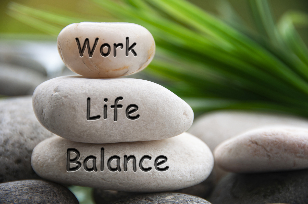 Stacked stones labeled “Work,” “Life,” and “Balance,” symbolizing the challenge of maintaining work-life balance.
